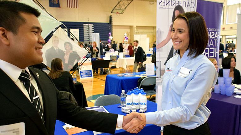 Student and Employer shaking hands at career fair